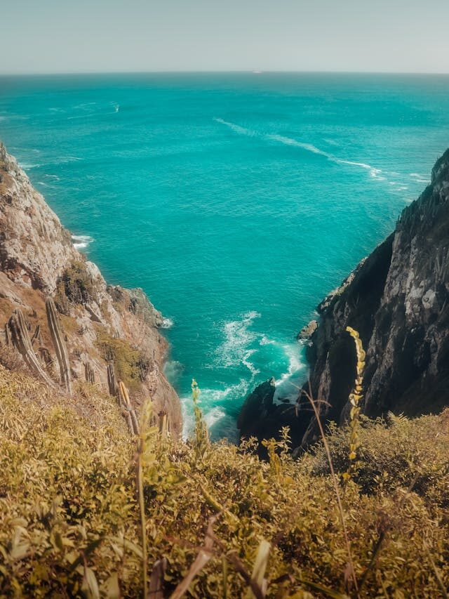 Mar cristalino com ondas batendo nas rochas em Arraial do Cabo